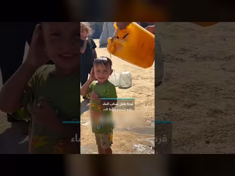فرحة طفل فلسطيني بسكب الماء عليه في غزة