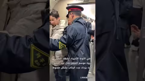 مسؤول الأمن الصيني يساعد راكبين كفيفين خلال عيد الربيع